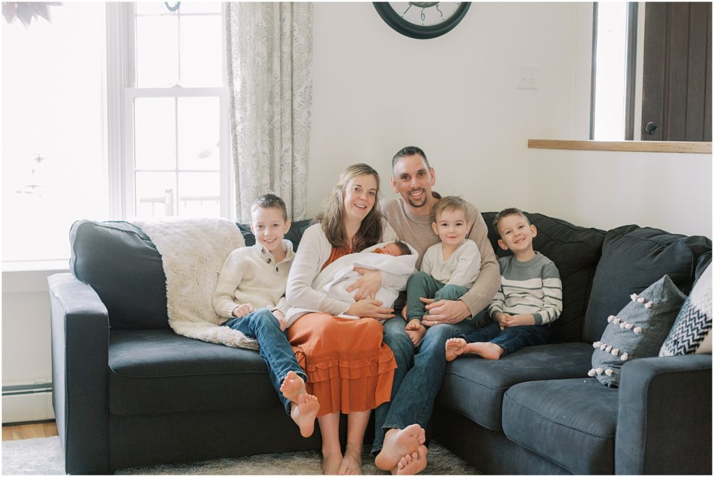 Family with newborn baby on the couch at an in home session