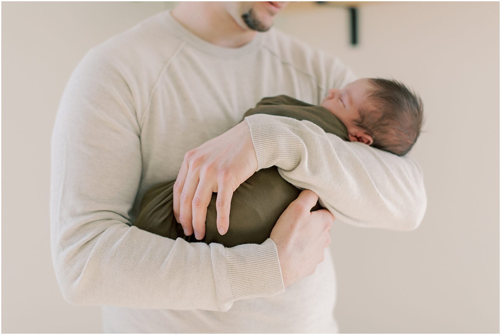 father's arms with newborn baby boy