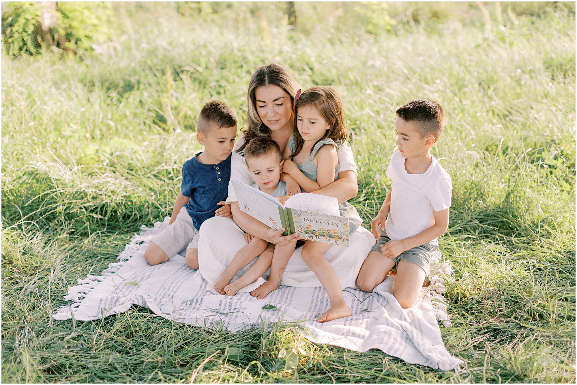 Mother reading to children in pasture