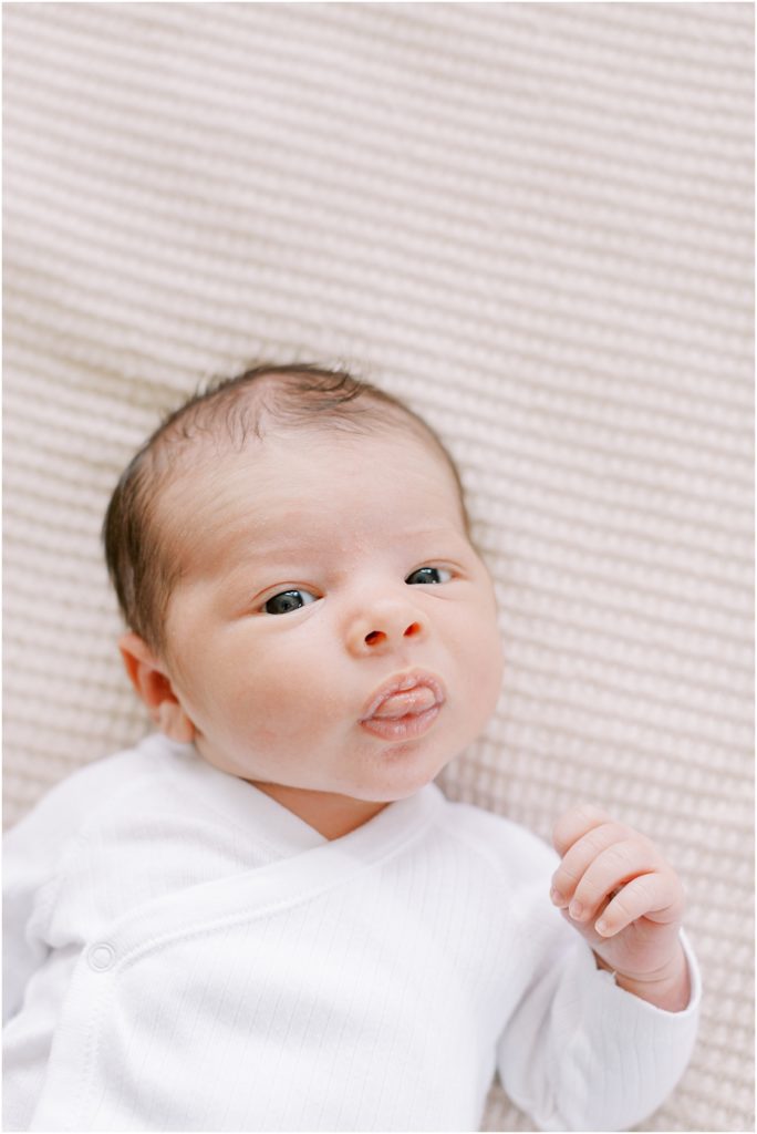 Baby boy with tongue out at summer indoor newborn session