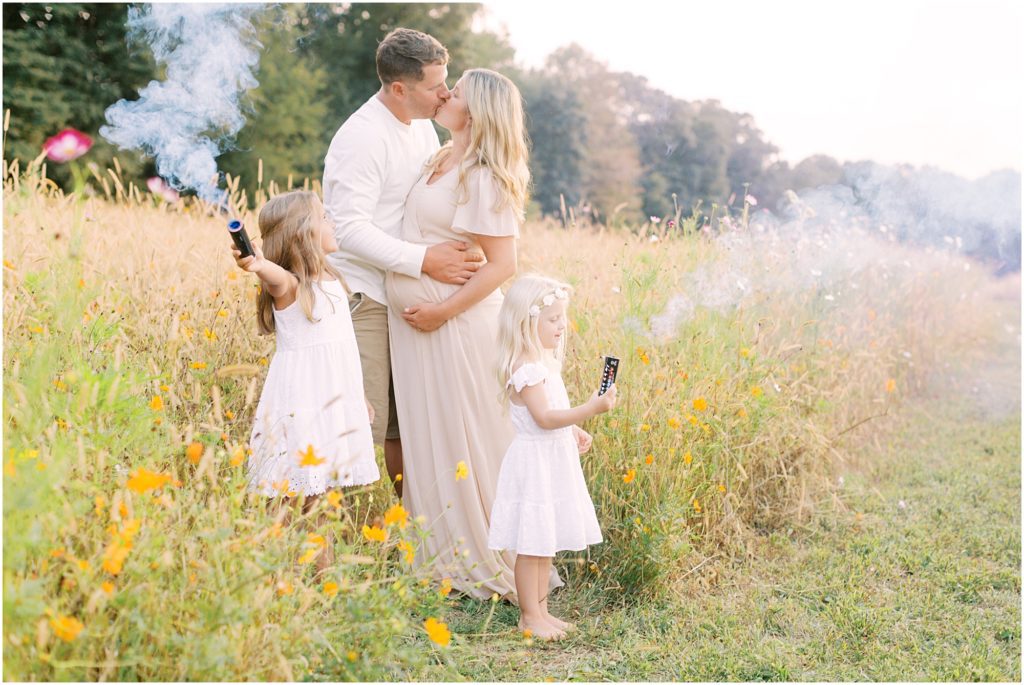 Parent's kissing the smoke bombs at maternity session