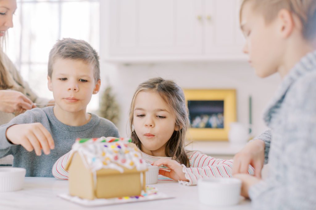 kids decorating a gingerbread house