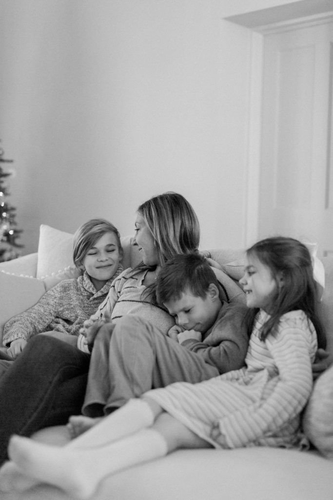 Black and white image of momma snuggling with kids