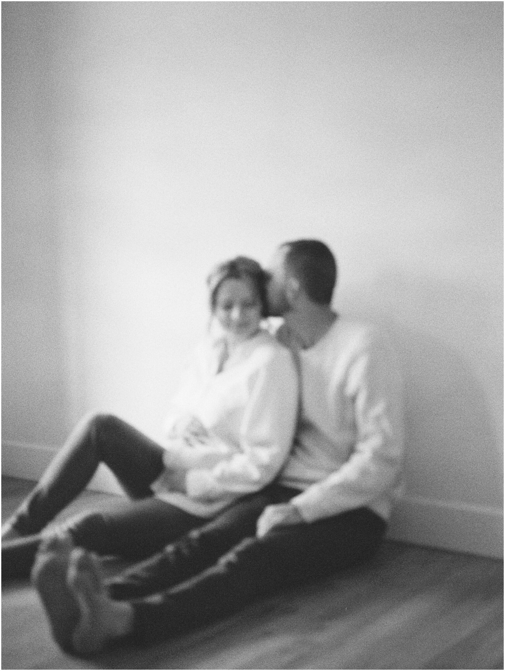 Blurry image of couple sitting on the floor of an indoor maternity session in York, PA
