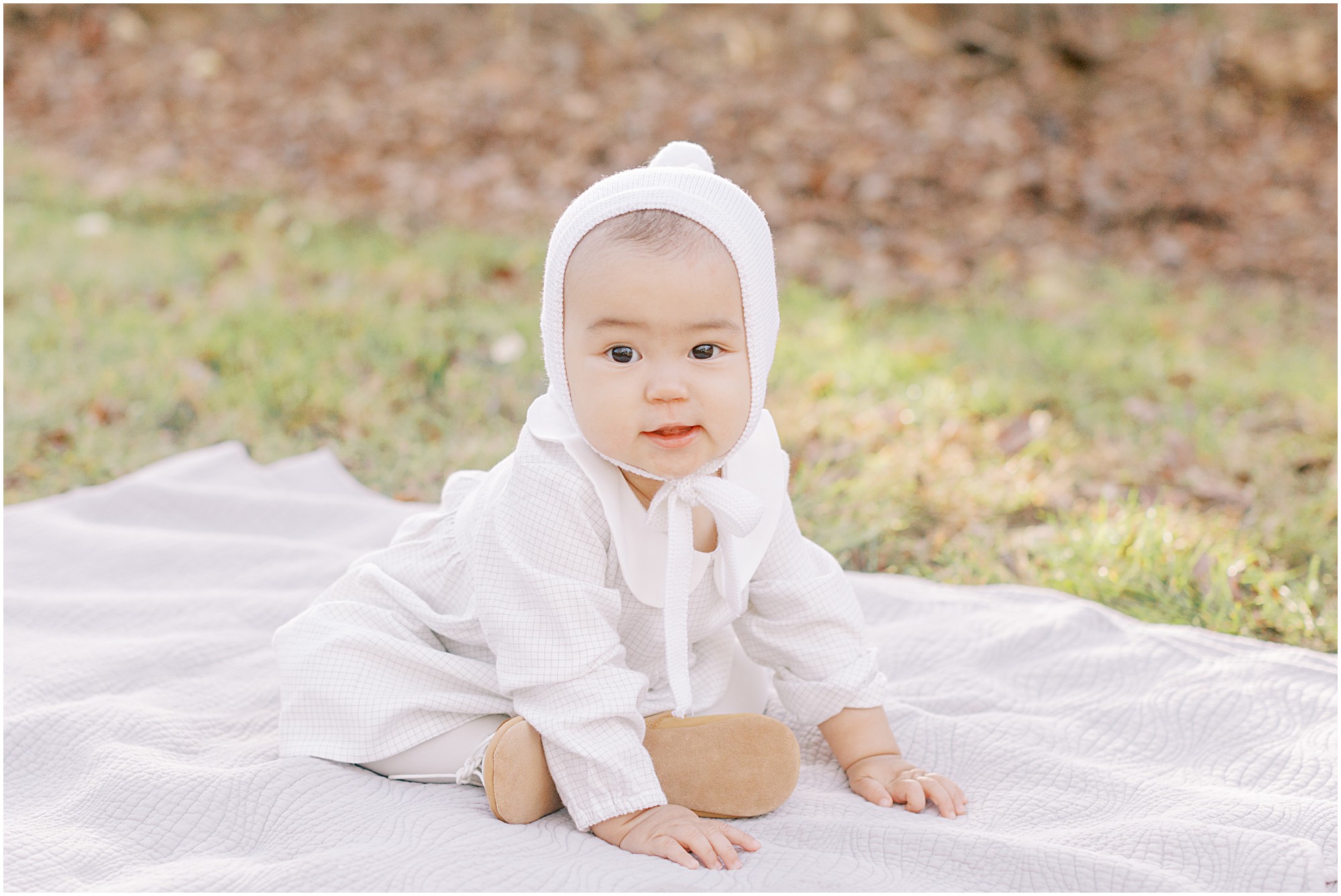 Baby girl sitting on a blanket at a family session