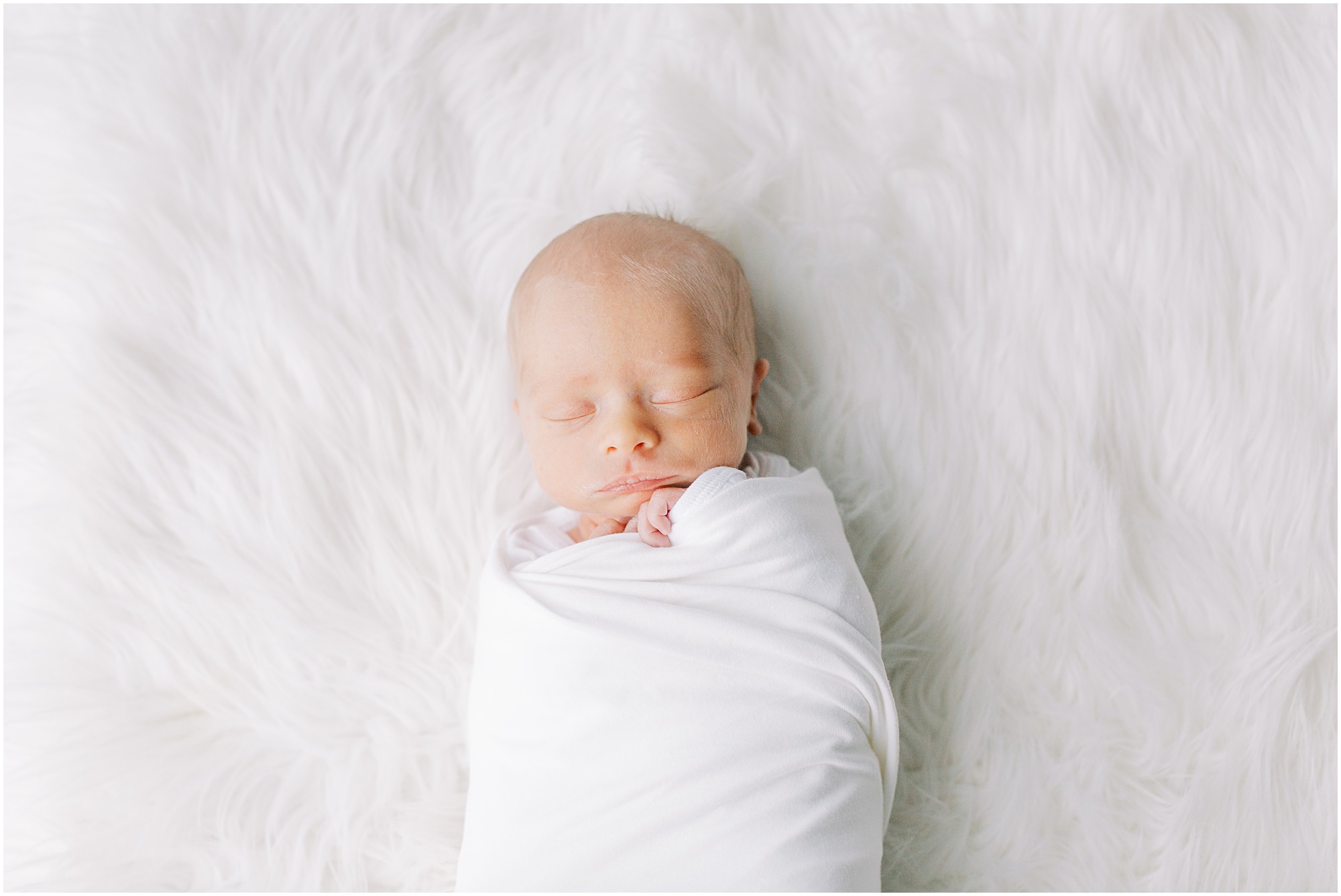 Newborn baby boy in white at a newborn session with boys