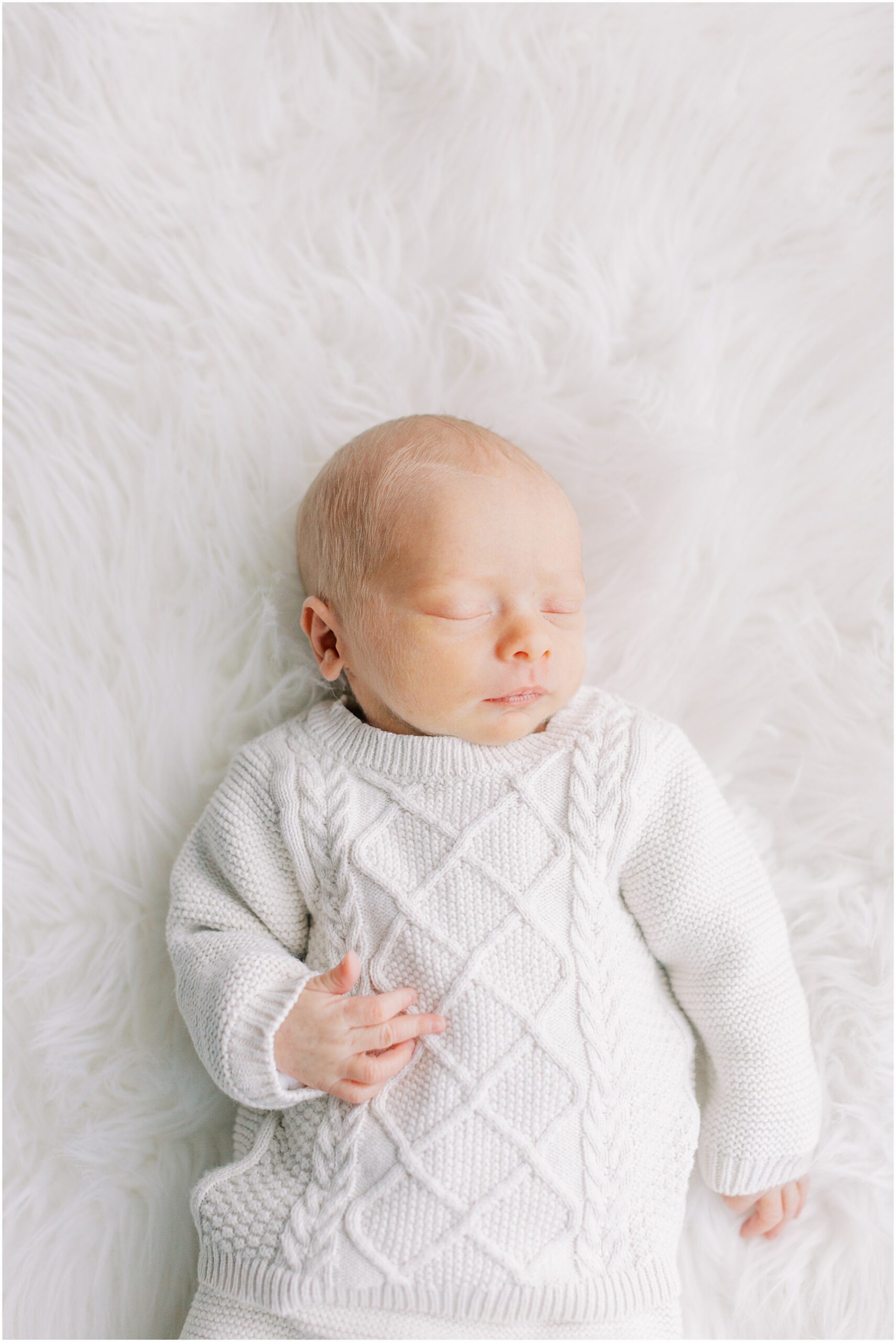 Newborn baby boy on white fur background