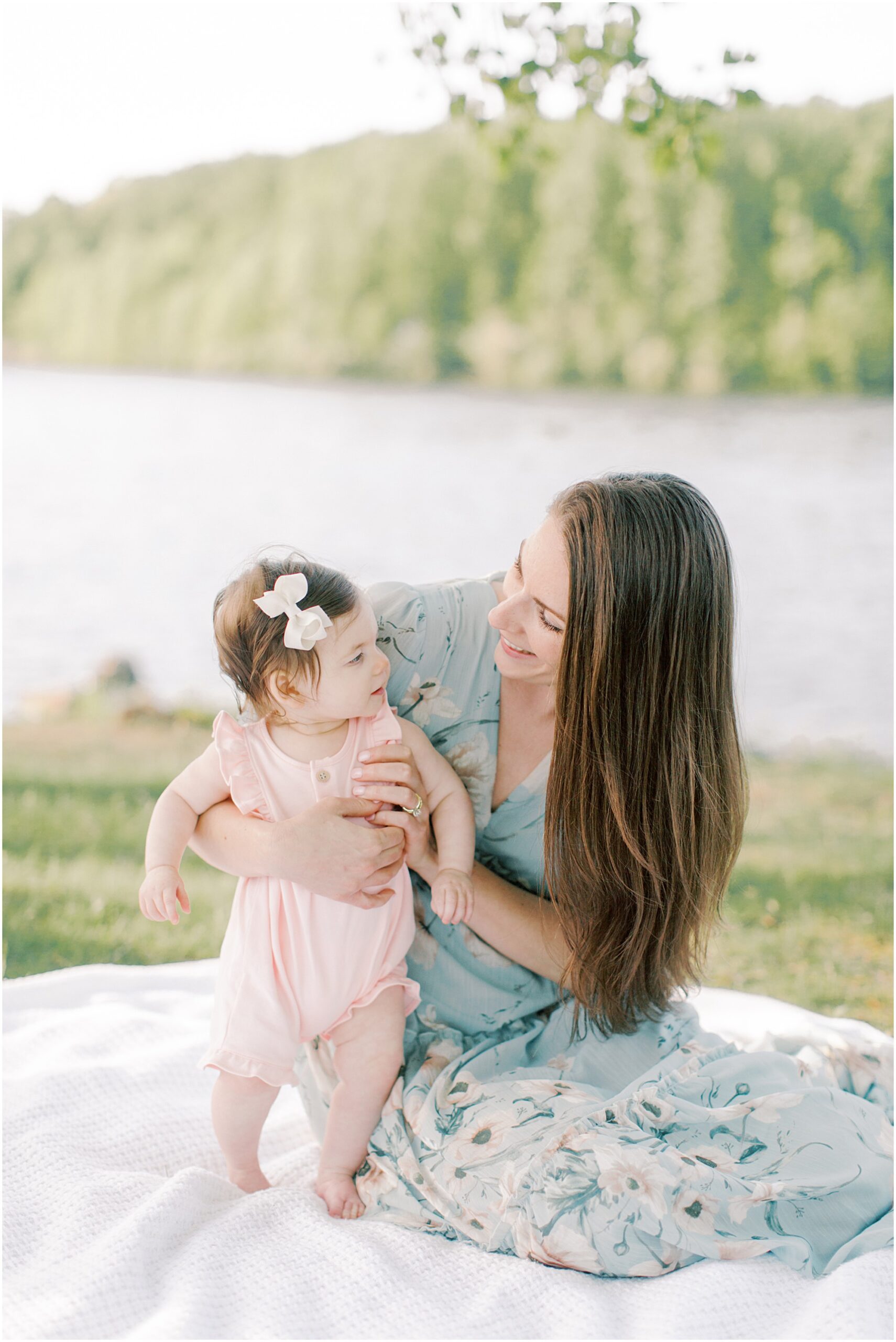 Mother hold up her baby girl on a blanket next to Chambers Lake