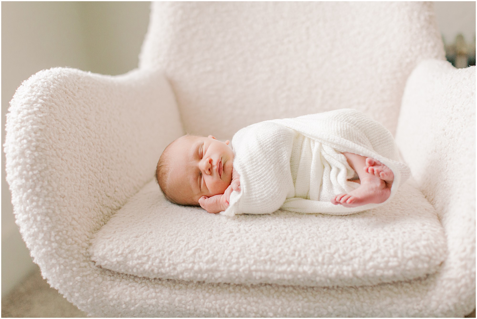 Baby lying on sherpa chair in three tips for a successful newborn session