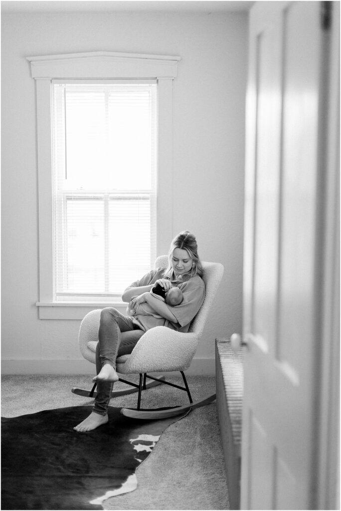 Black & white image of a mom rocking her newborn in How to Help a Postpartum Mom