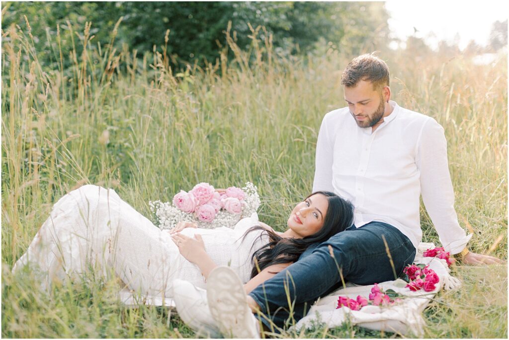 Woman laying with her head on her husband's leg at an Intimate Maternity Session