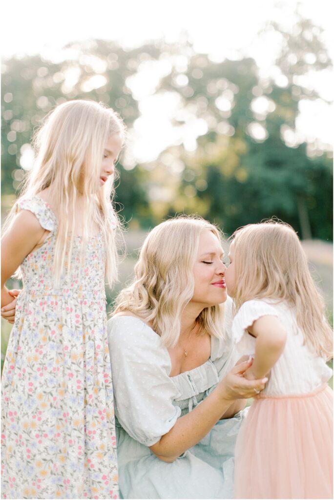 Mother and daughters together while mom does Eskimo kisses with the youngest daughter