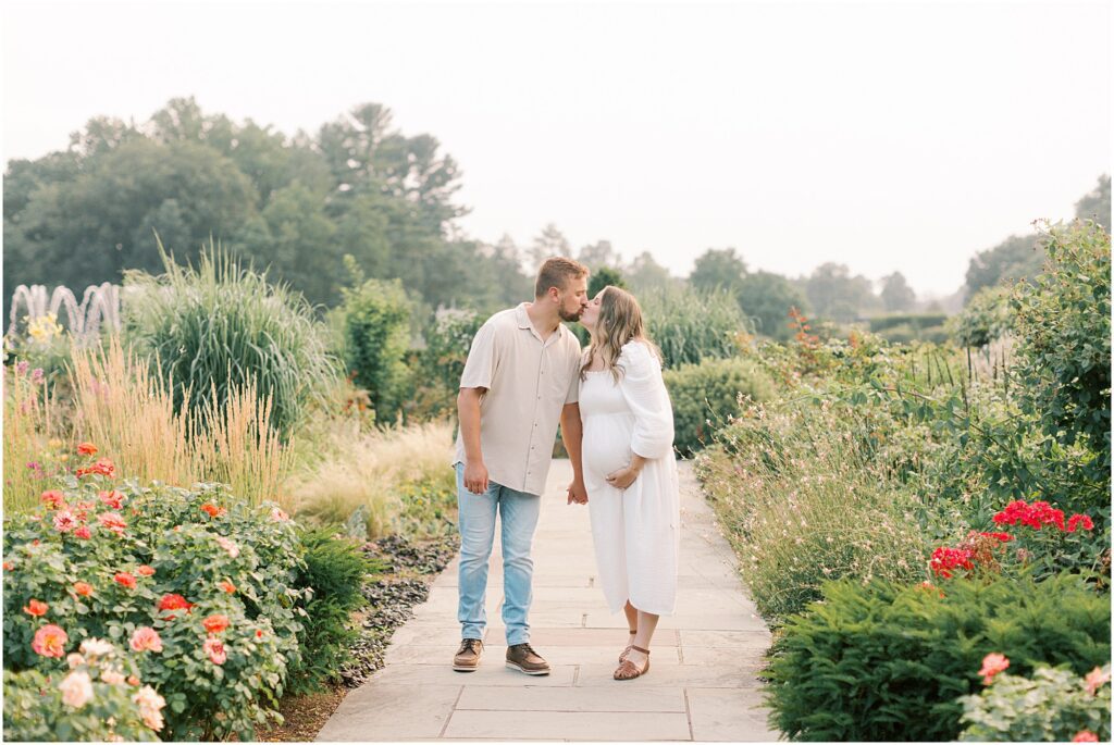Couple kissing in the Rose Garden at a maternity session at Longwood Gardens.
