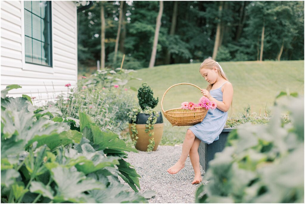 Young girl sitting in a garden with a basket of flowers