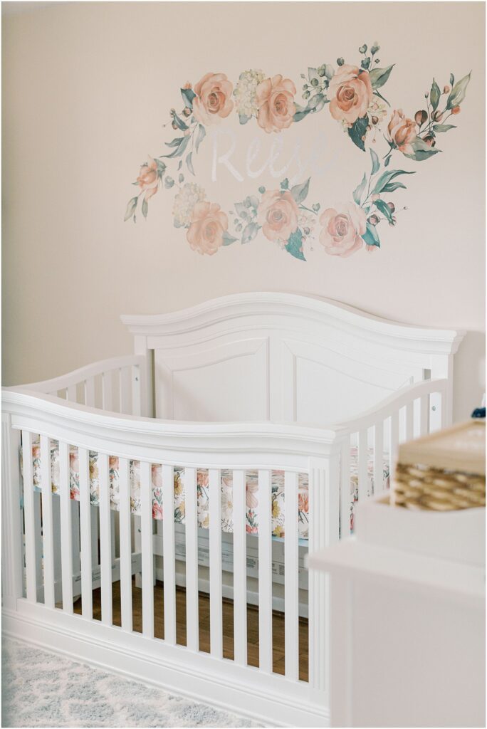 Details of the crib and wall decor in a baby girl's nursery