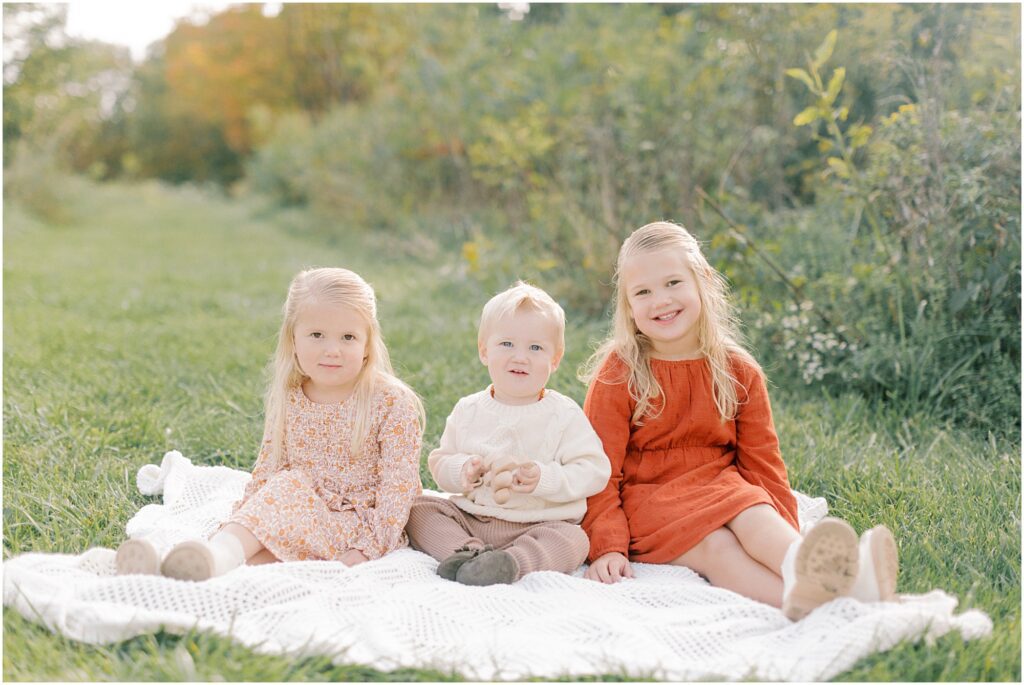 Kids sitting on a blanket at a family session