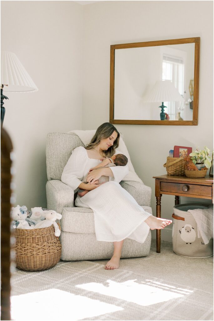 A mother rocking her newborn in a recliner in the nursery in a simple tip for expecting mothers.