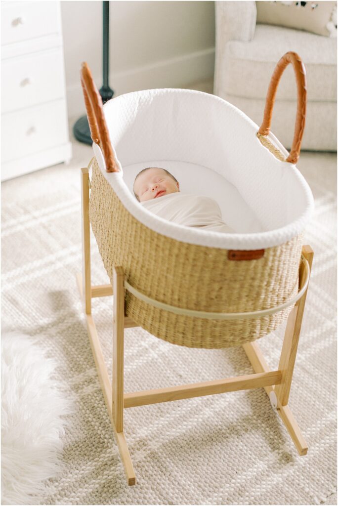 Baby boy in a bassinet in a stand in the nursery