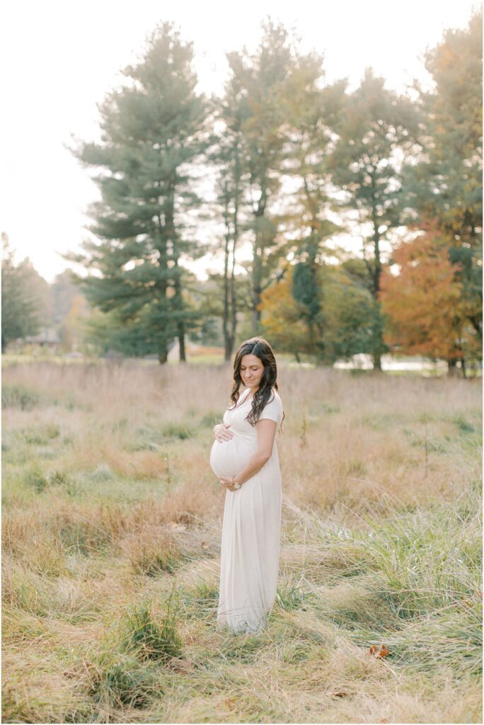 Pregnant woman in a field looking down