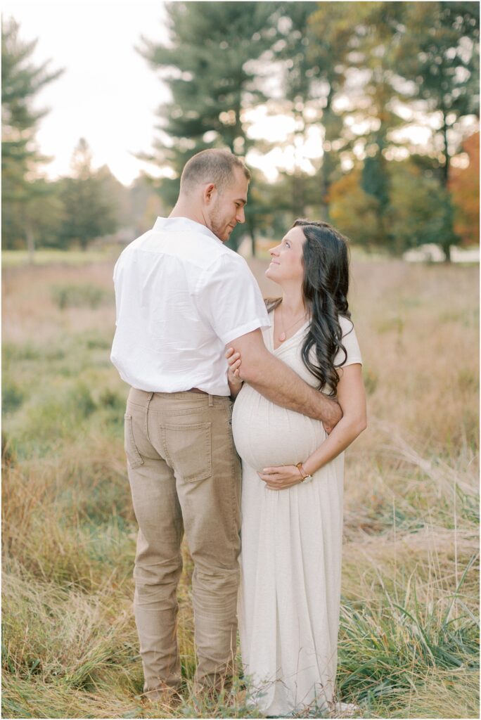 Expecting couple with arms around each other in a Lancaster County Central Park Maternity Session