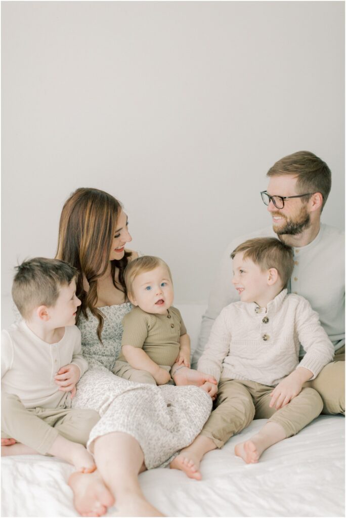 Family snuggling together on a bed at a session with Angelique Jasmin Photography