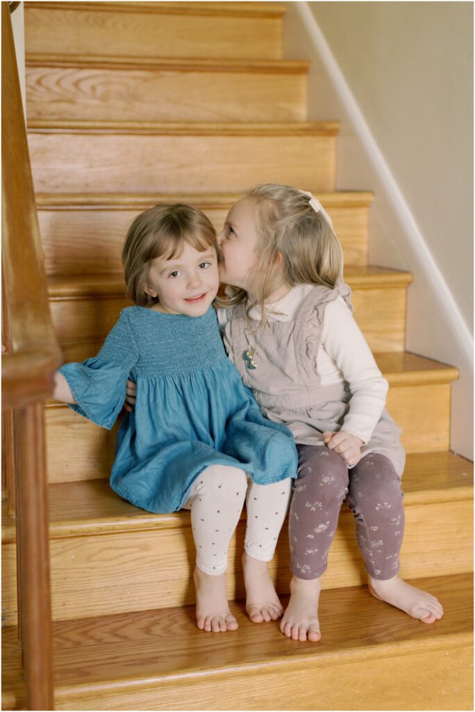 Sisters whispering on the stairs 